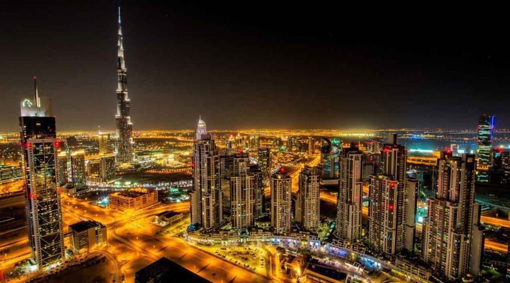 Dubai skyline at night with illuminated towers including Burj Khalifa